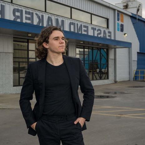 An image of a man, Zimri T. Hinshaw, standing outside a production theater.